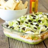 glass casserole dish full of 7 Layer Chicken Taco Dip