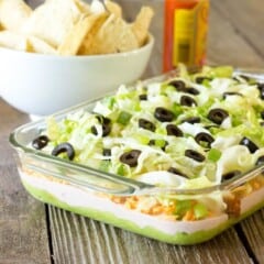 glass casserole dish full of 7 Layer Chicken Taco Dip