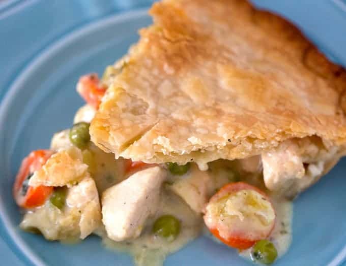 Slice of classic chicken pot pie with pie crust and creamy filling