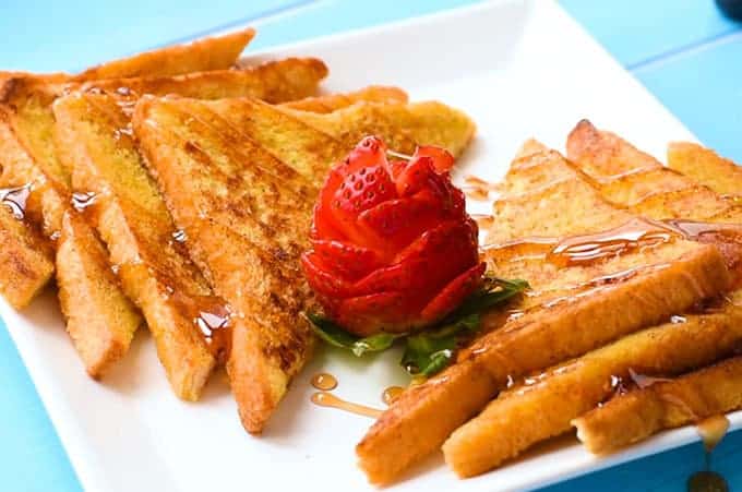 the best french toast sliced on a plate with a strawberry