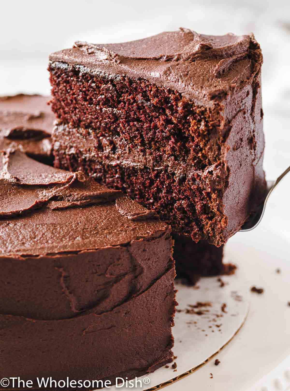 slice of chocolate layer cake being lifted up away from the cake