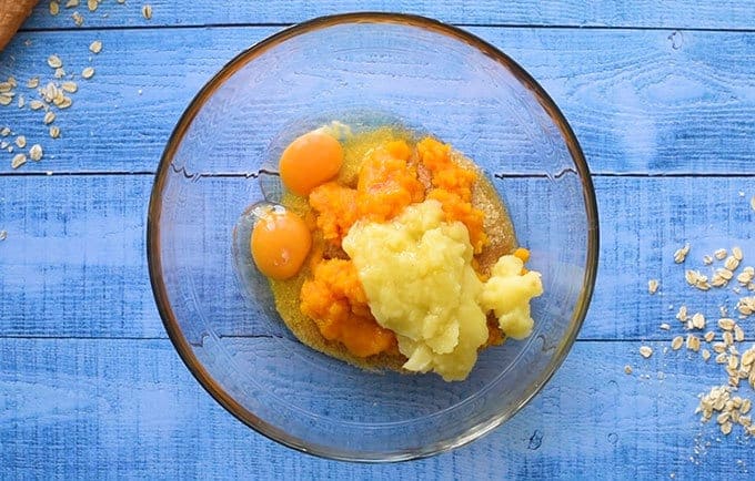 Easy baked oatmeal ingredients in a bowl: sugar, brown sugar, pumpkin puree, applesauce, and eggs