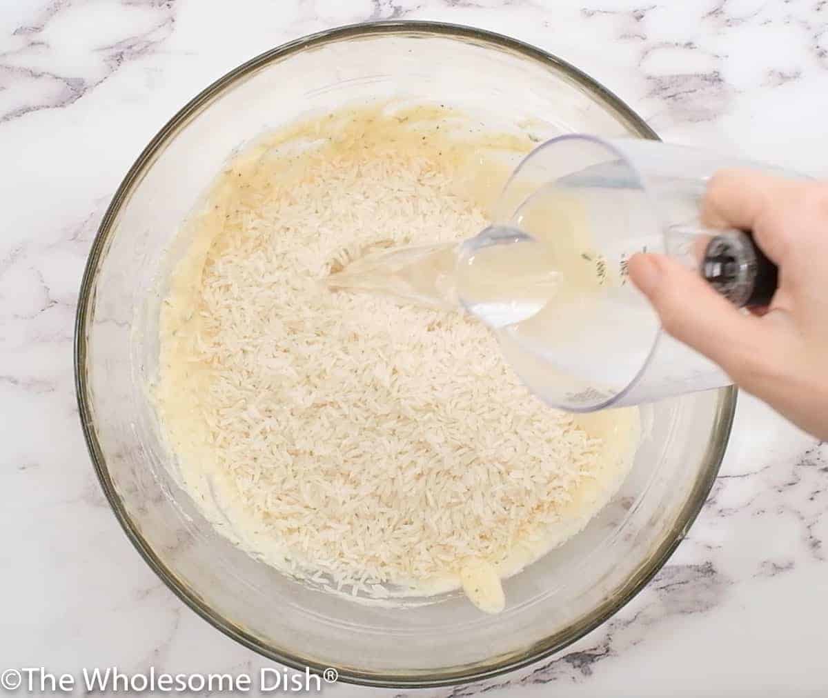 Adding rice and water to the mixing bowl.