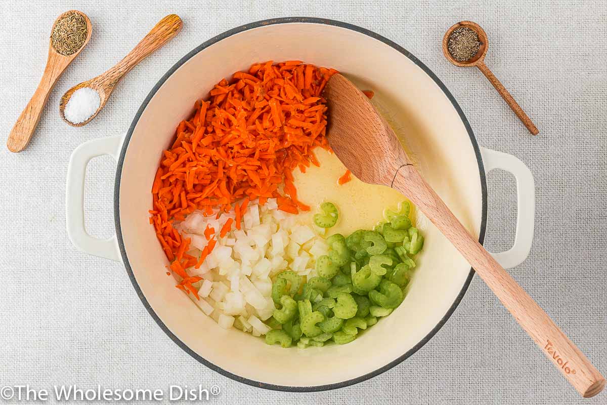 Cooking carrots, celery, and onions in a large soup pot.