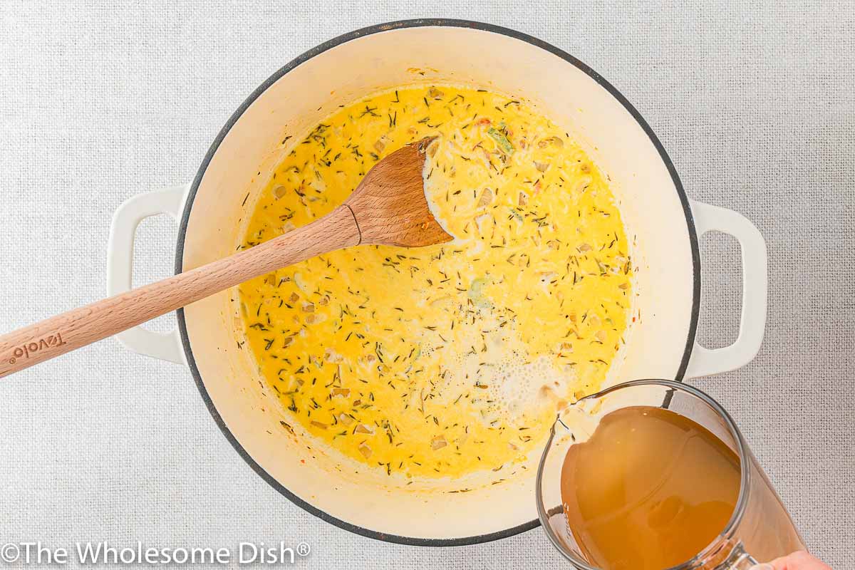 Adding broth to the soup pot.