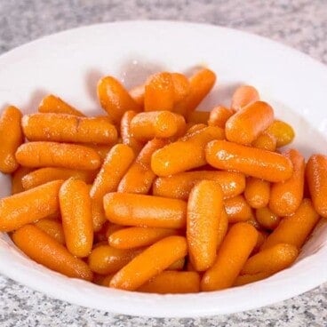 white bowl full of Crock Pot Cinnamon Brown Sugar Carrots 1