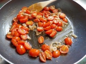 tomatoes sautéing in a skillet