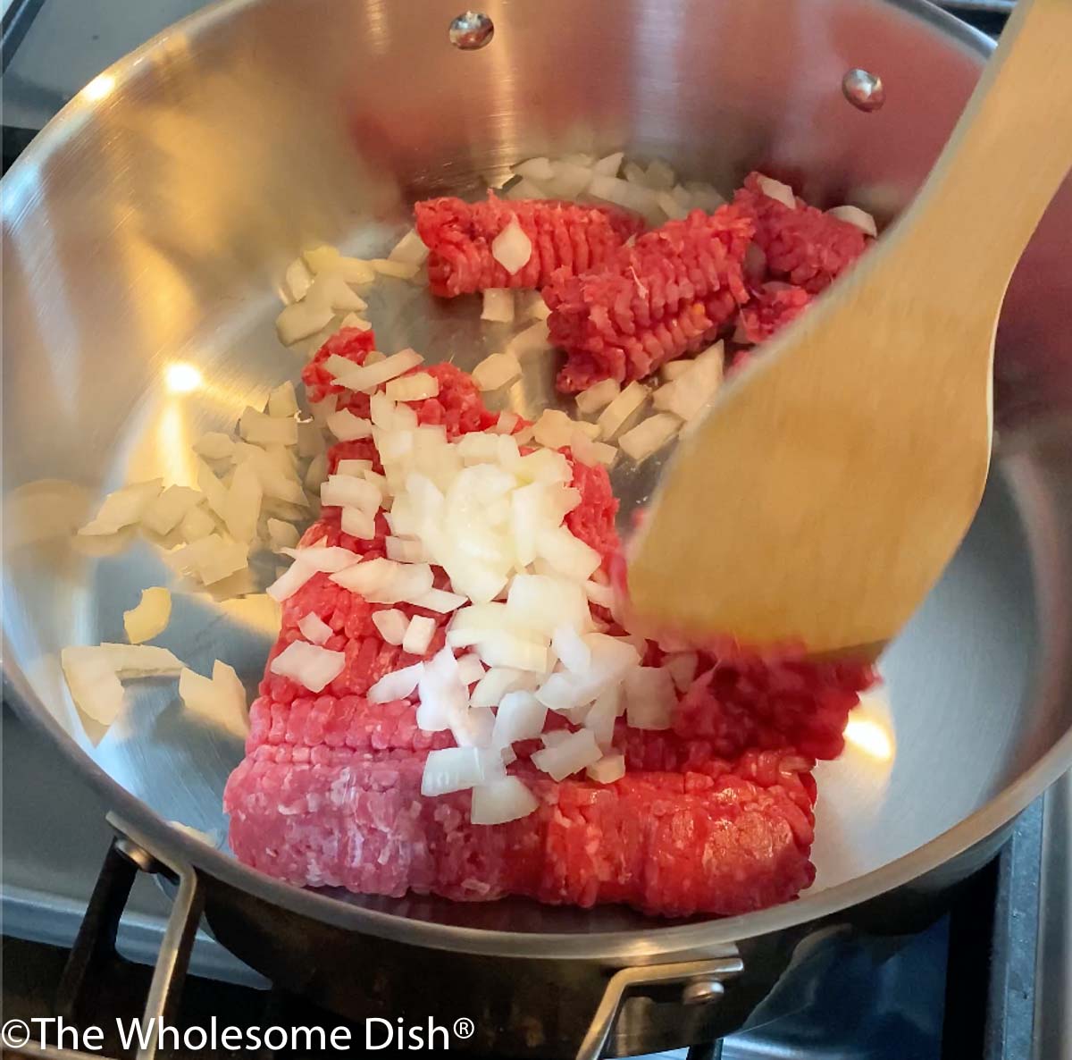 Ground beef and chopped onion in a skillet.