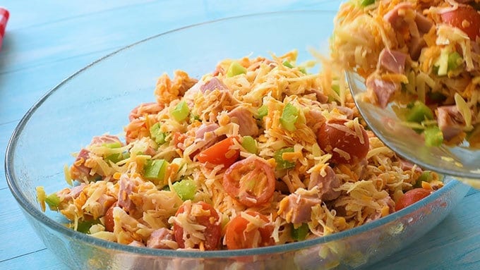 Pouring make ahead breakfast casserole ingredients into a baking dish