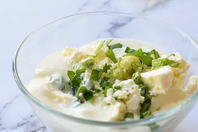 The feta mixture for Greek Bruschetta with crumbled feta cheese, Greek yogurt, minced garlic, and chopped basil leaves