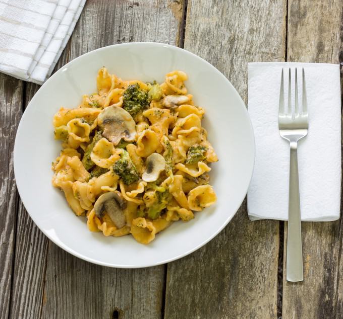 One Pot Wonder Pasta Con Broccoli in a white bowl on a wood table next to a fork and napkin