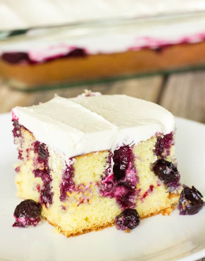 slice of Blueberry Lemon Poke Cake on a white plate