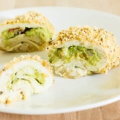 sliced guacamole chicken breast on a white plate