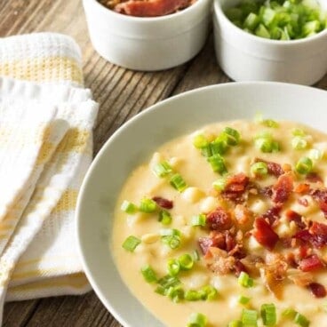 white bowl full of Skinny Crock Pot Loaded Potato Soup and toppings