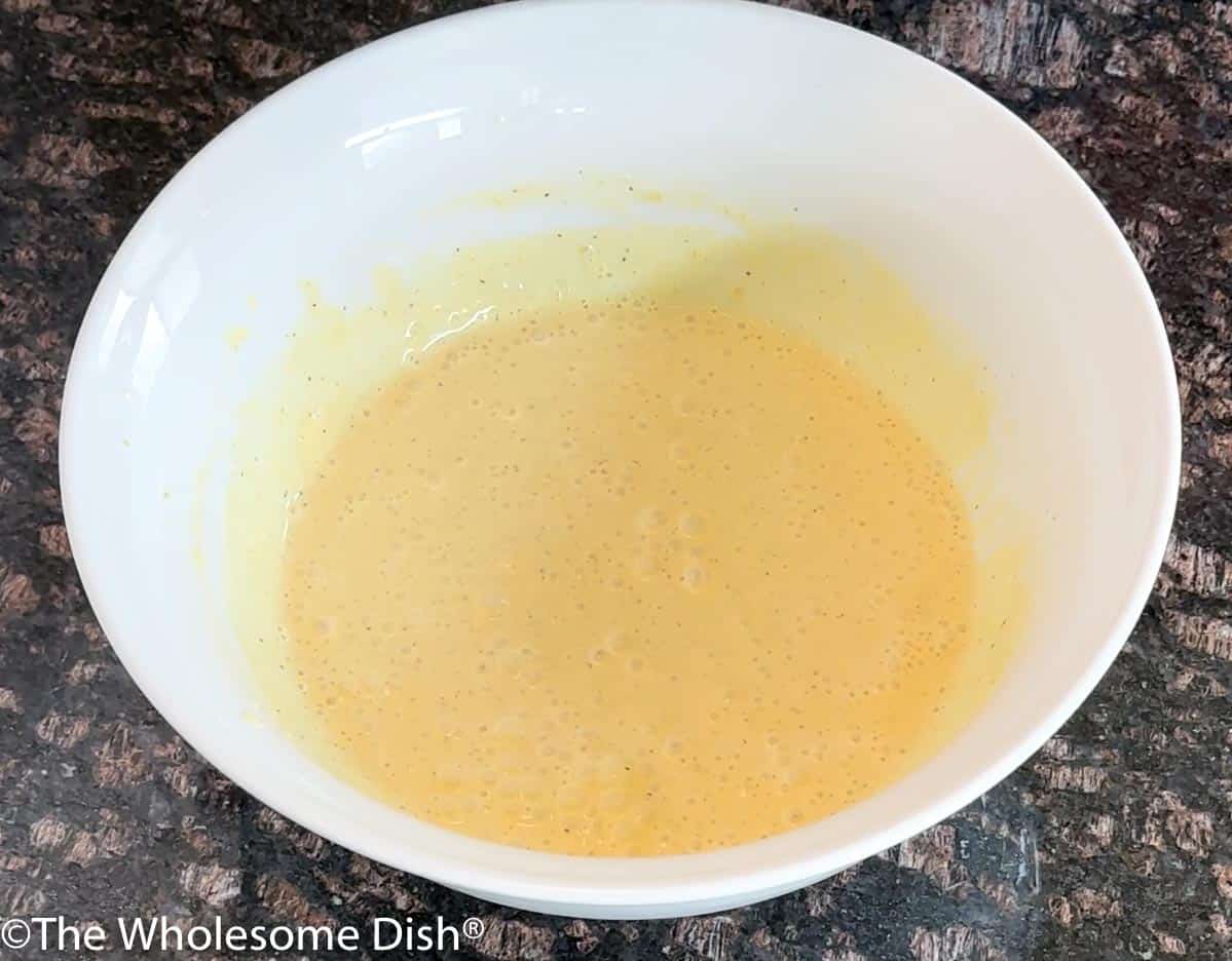 Macaroni salad dressing in a white bowl.