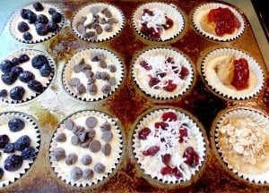 uncooked muffin batter in a muffin tin with different toppings sprinkled on the batter