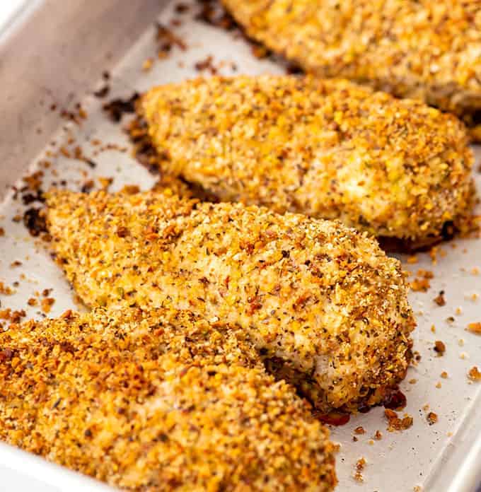 Baking dish full of cooked pistachio crusted chicken breasts