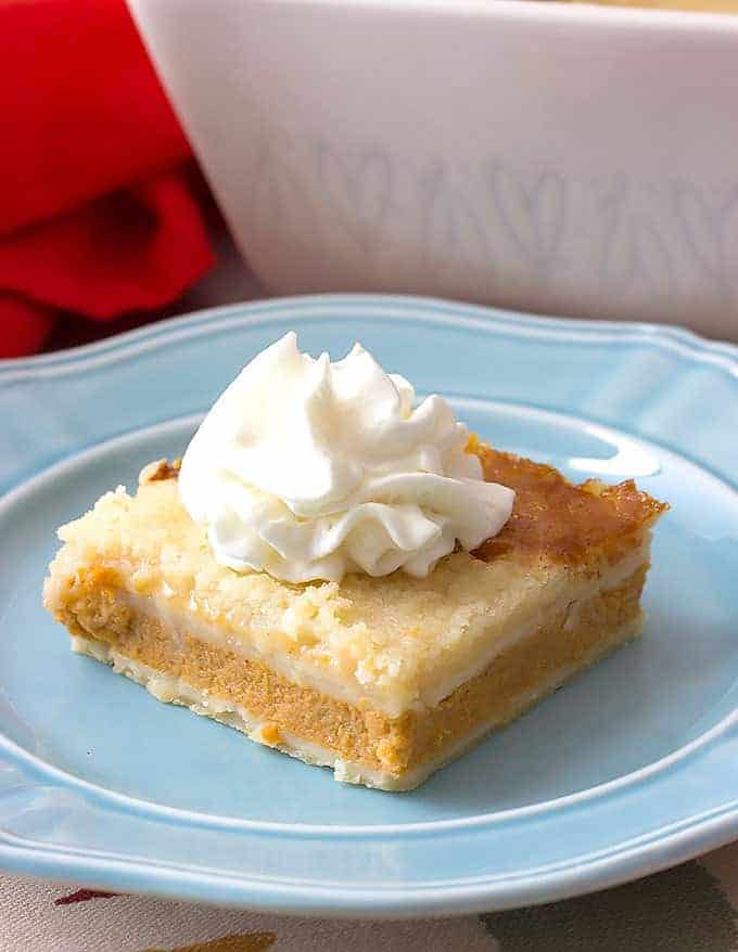 Pumpkin Pie Cobbler topped with whipped cream on a blue plate