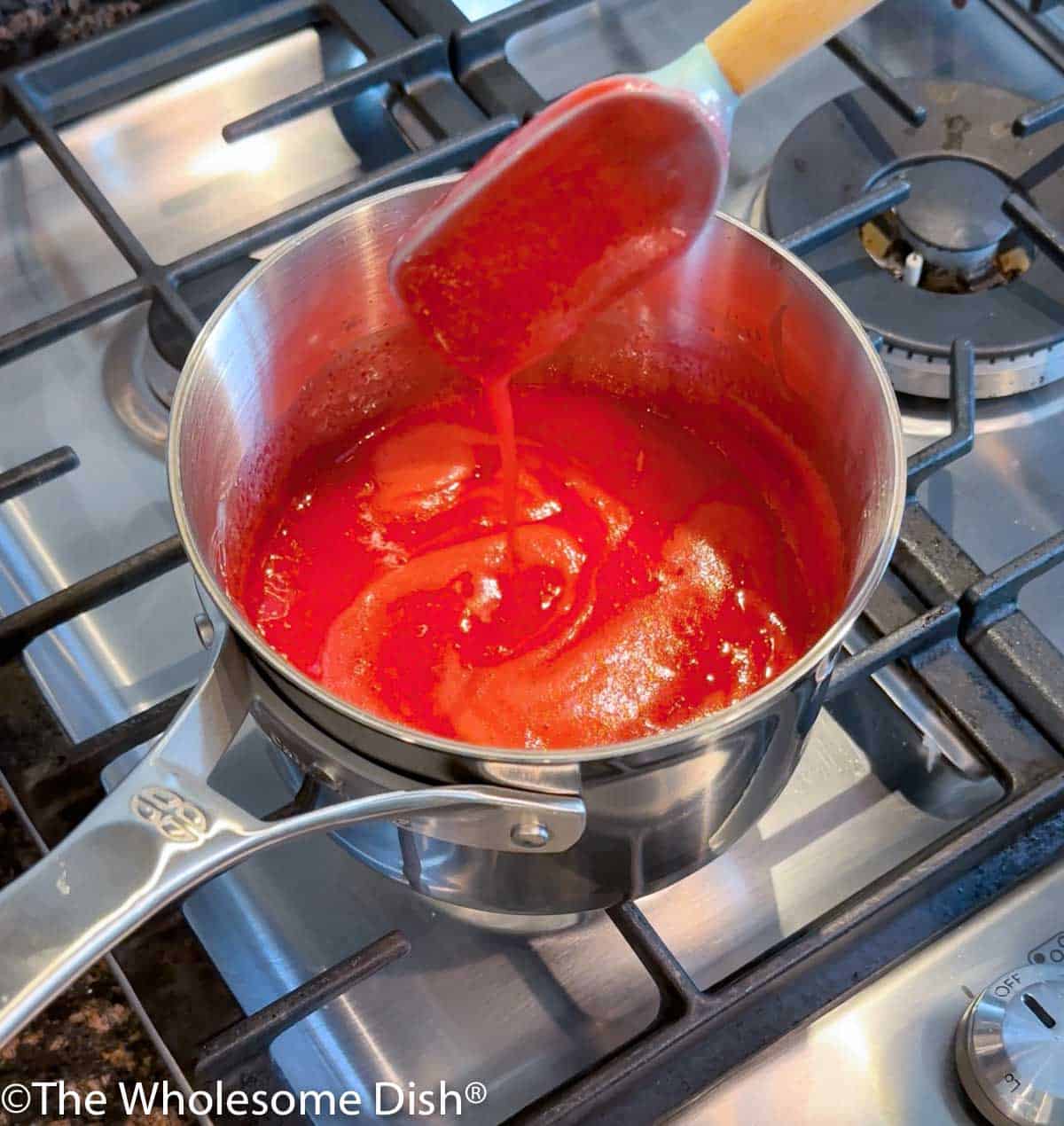 Pot with boiling strawberry jello ingredients.