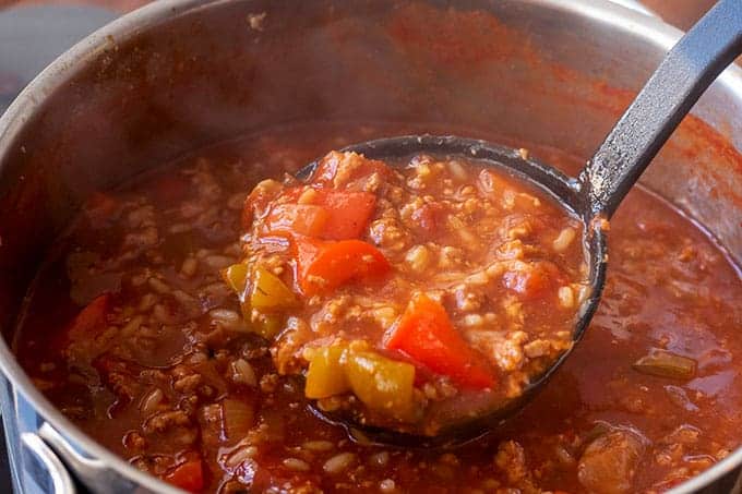 Stuffed pepper soup being labeled out of a pot