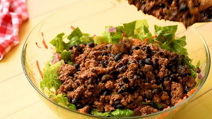 Adding taco seasoned beef to easy taco salad