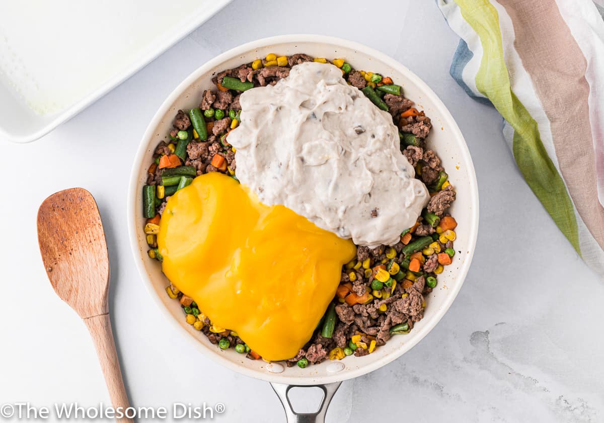 Cream of mushroom and cheddar cheese soup added to a skillet of beef and vegetables.