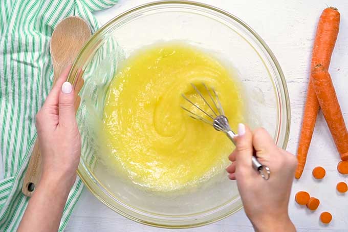 Mixing bowl full of sugar, oil, eggs, and vanilla for the best carrot cake