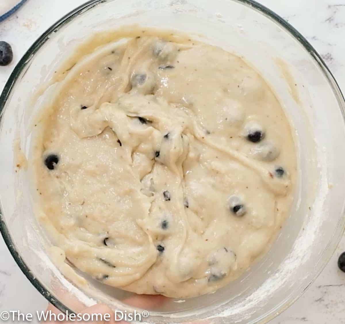 Mixing bowl full of blueberry muffin batter.