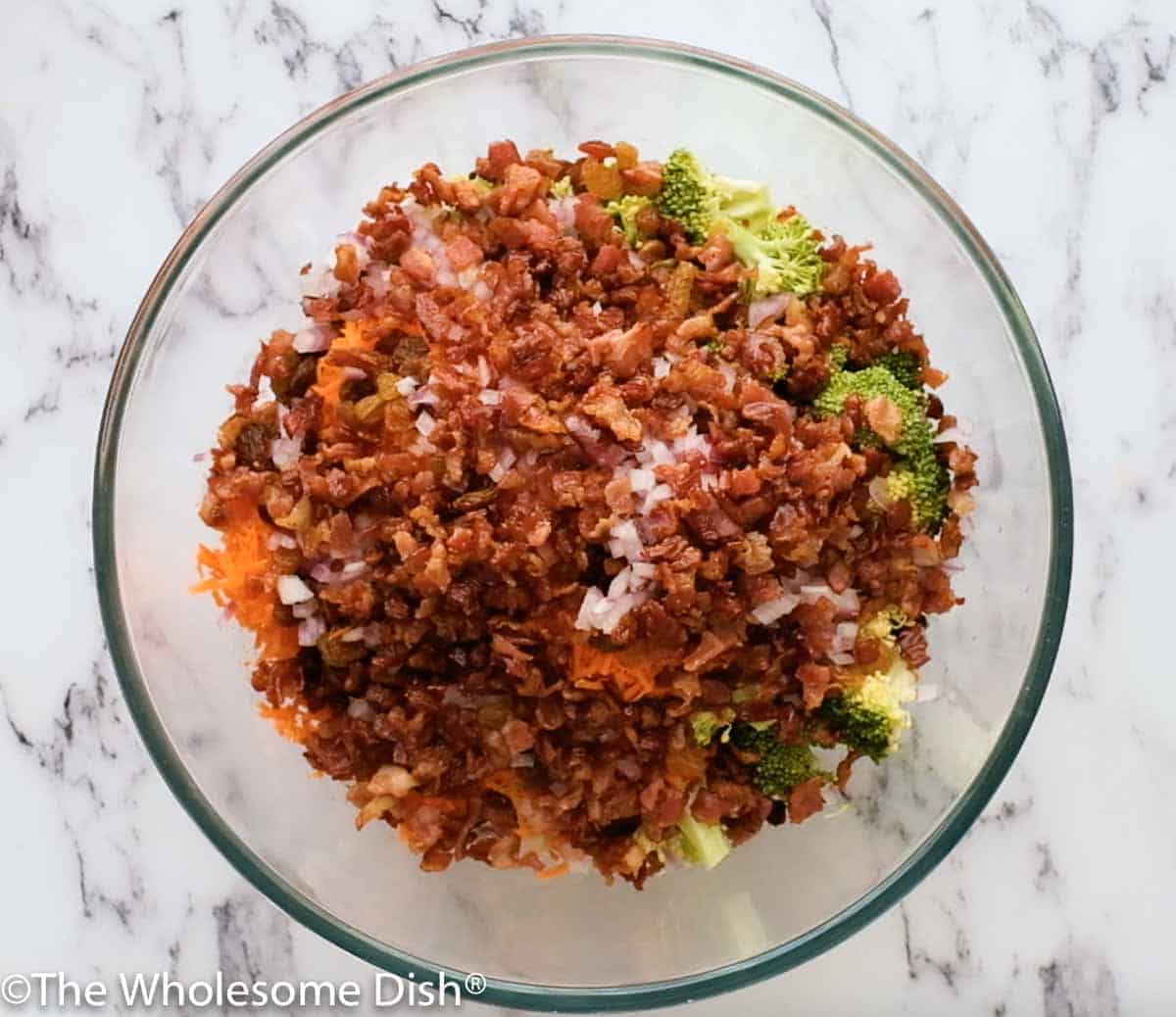 large mixing bowl with the chopped ingredients for broccoli salad, ready to be stirred