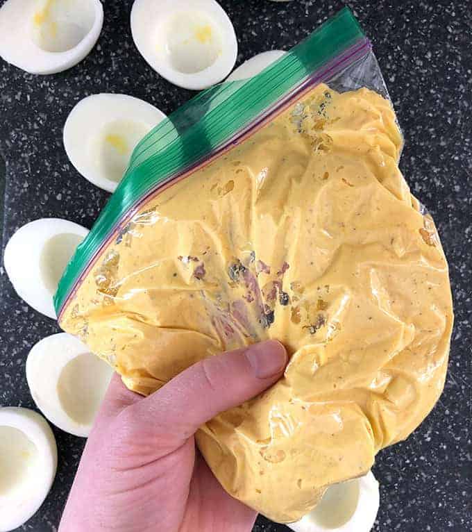 Deviled egg filling being squeezed until smooth in a plastic bag