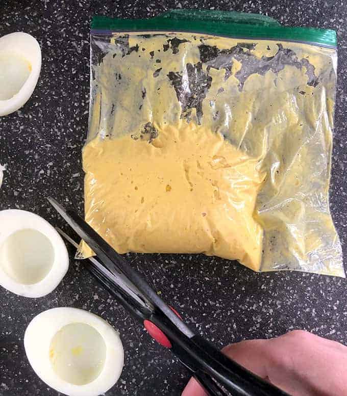 Cutting the corner off a bag of filling for deviled eggs