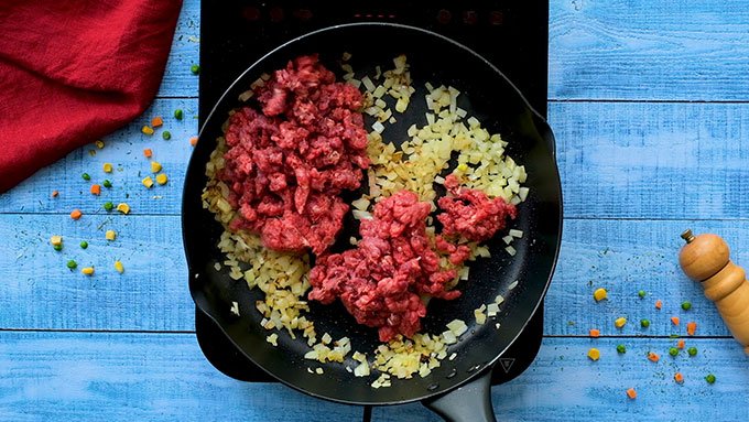 Skillet full of sautéed onions and ground beef for The Best Classic Shepards Pie Recipe