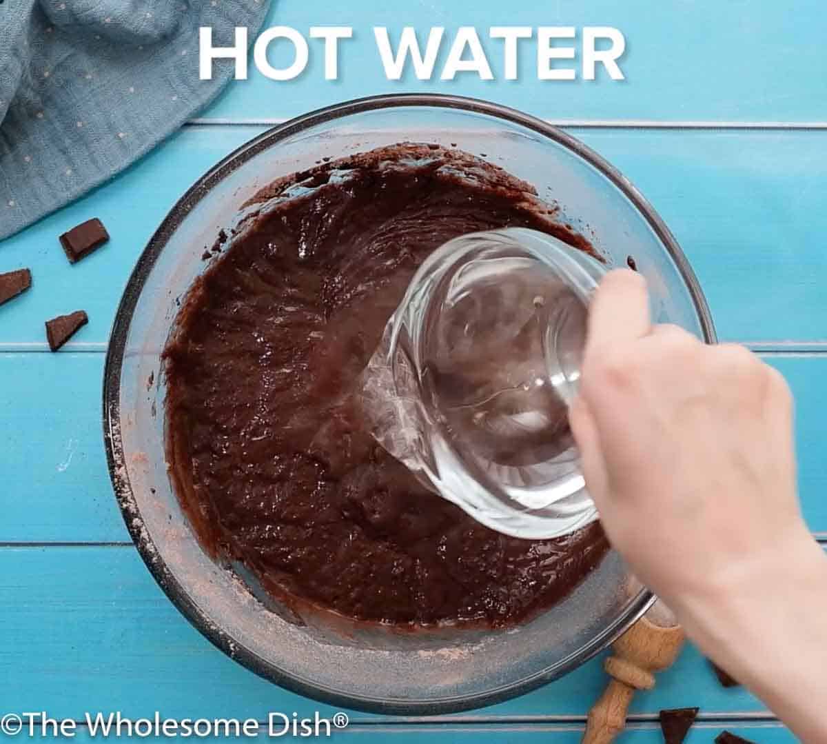 Adding hot water to a bowl of cake batter